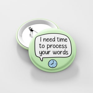 May include: A light green button with a white speech bubble that says "I need time to process your words". A blue clock face with black hands is below the speech bubble.