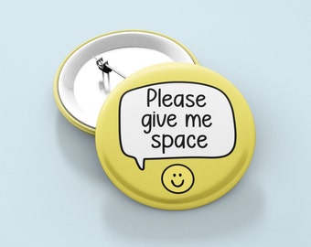 May include: Yellow button with a smiley face and a speech bubble that says "Please give me space".