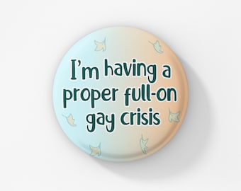 Könnte beinhalten: Runder Button mit einem Farbverlauf aus Hellblau und Pfirsich, mit dem Text "I'm having a proper full-on gay crisis" in Dunkelgrün. Kleine Blattillustrationen sind um den Text herum verstreut.