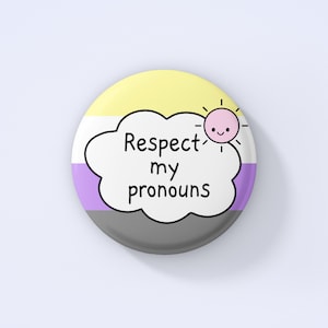 May include: A round button with a yellow, white, purple, and gray design. The button has a white cloud with the text "Respect my pronouns" and a yellow sun with a pink face.