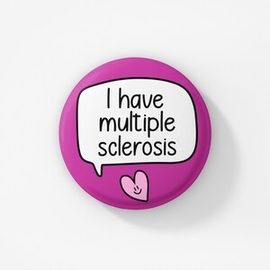 Pu&ograve; includere: Bottone rosa con un fumetto bianco che dice "Ho la sclerosi multipla" e un cuore rosa con un faccina sorridente.