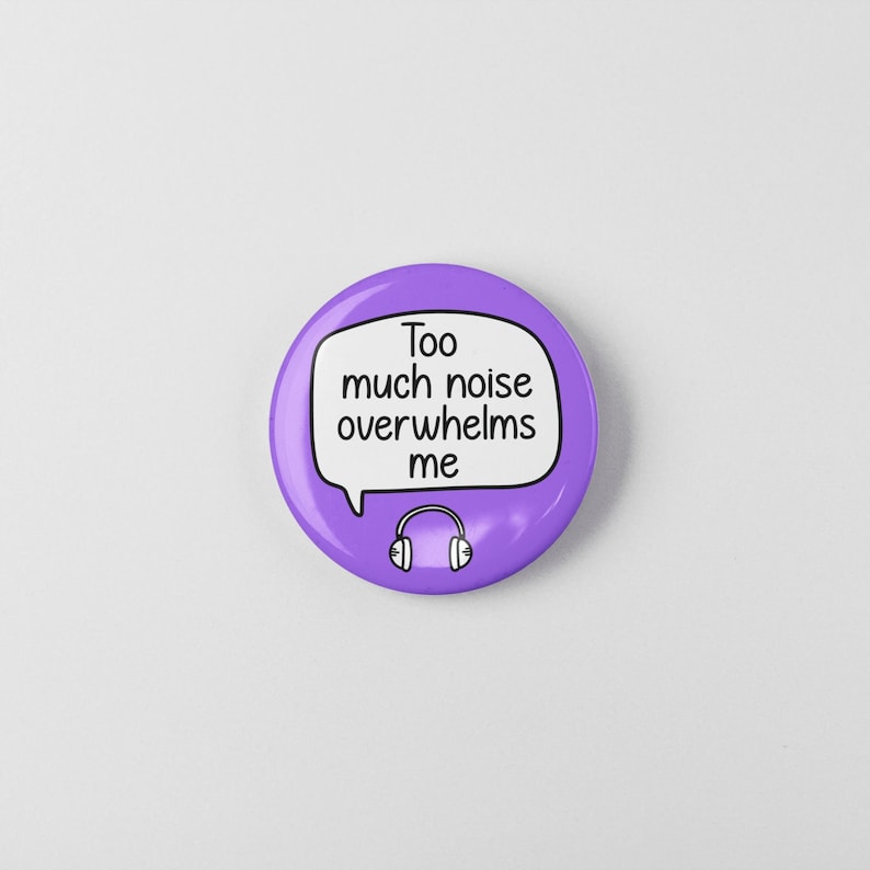 May include: Purple button with a speech bubble that says "Too much noise overwhelms me" and a black and white illustration of headphones.