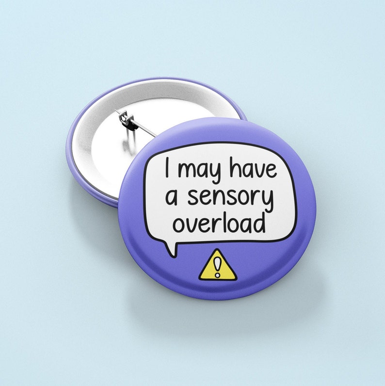 May include: Purple button with a white speech bubble that says "I may have a sensory overload" with a yellow exclamation point in a triangle.