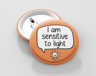 May include: Orange button with a white speech bubble that says "I am sensitive to light" and a lightbulb icon.