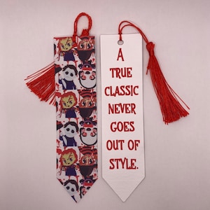 May include: Two decorative bookmarks with red tassels. One features a repeating pattern of cartoon horror characters. The other bookmark is white with the text "A TRUE CLASSIC NEVER GOES OUT OF STYLE" in red.