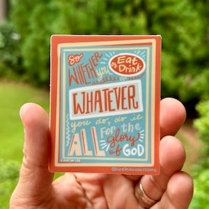 May include: A sticker with a blue and orange background featuring the text "So whether you eat or drink, whatever you do, do it all for the glory of God." The sticker also includes the scripture reference "1 Cor. 10:31" and the social media handle "@uncleduncsstickers".