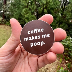May include: A brown circle sticker with white text that reads "coffee makes me poop."