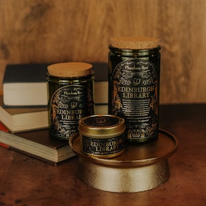 Side by side shot of the three sizes of Edinburgh Library soy candles – 15 oz jar, 11 oz jar, and 3.3 oz gold tin