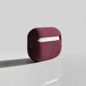 Puede incluir: Una funda de terciopelo burdeos para auriculares inal&aacute;mbricos. La funda tiene una textura suave y afelpada y un cierre de cremallera.