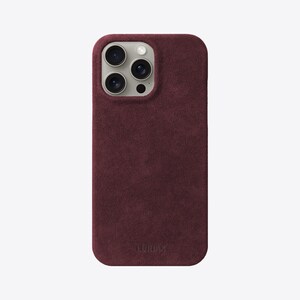 May include: A burgundy suede phone case with a raised camera bump and the word "LURVEY" embossed on the bottom.