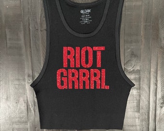 May include: Black tank top with a red glitter graphic that says "RIOT GRRRL".