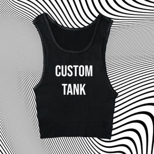 Könnte beinhalten: Schwarzes geripptes Tanktop mit den Worten "CUSTOM TANK" in weißen Blockbuchstaben. Das Tanktop ist ärmellos mit einem Rundhalsausschnitt. Der Hintergrund hat ein schwarz-weißes Wellenmuster.