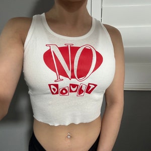 Op de afbeelding: Witte crop top met een rood hart en de tekst "NO DOUBT" erop gedrukt.