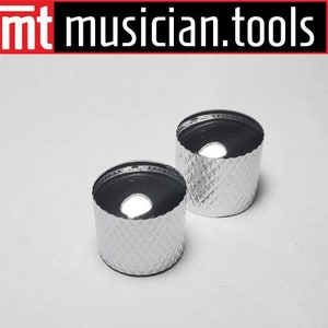 May include: Two silver-colored guitar knobs with a diamond pattern. The knobs are round with a flat top and a small hole in the center.