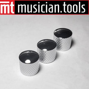 May include: Three silver-colored control knobs with a diamond pattern on the sides and a black top. The knobs are arranged in a diagonal line against a white background. The text "mt musician.tools" is in the top left corner.