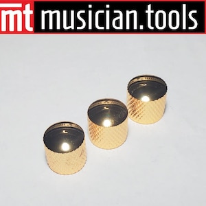 May include: Three gold-colored guitar knobs with a textured surface.