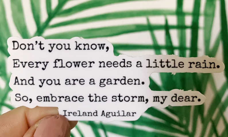 May include: A white sticker with black text that reads: "Don't you know, Every flower needs a little rain. And you are a garden. So, embrace the storm, my dear." The author's name, Ireland Aguilar, is at the bottom.