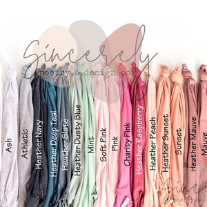 May include: A collection of folded t-shirts in various colors, including black, white, and shades of gray, blue, pink, and maroon. The shirts are arranged in a row, with the color names printed on the front. The text "Sincerely poetry & design co." is also visible.