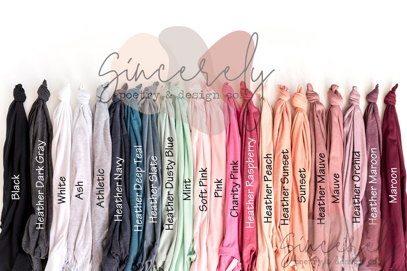 May include: A collection of folded t-shirts in various colors, including black, white, and shades of gray, blue, pink, and maroon. The shirts are arranged in a row, with the color names printed on the front. The text "Sincerely poetry & design co." is also visible.