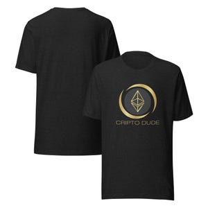 Puede incluir: Camiseta gris oscuro con un logotipo de Ethereum dorado y gris y el texto "CRIPTO DUDE". La camiseta de manga corta tiene cuello redondo. Otra camiseta es visible en el fondo.