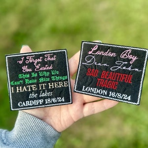 Pode incluir: Duas aplicações pretas bordadas com bordas brancas são exibidas em um fundo verde. Uma aplicação diz "I Forgot That You Existed" e "I HATE IT HERE" com o texto "CARDIFF 18/6/24". A outra aplicação diz "London Boy" e "SAD BEAUTIFUL TRAGIC" com o texto "LONDON 16/8/24".