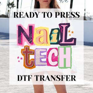 May include: White DTF transfer with the words "Nail Tech" in colorful, blocky letters. The words "Ready to Press" and "DTF Transfer" are also printed on the transfer. The transfer is designed to be pressed onto fabric.