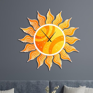 May include: A decorative wall clock in the shape of a sun, featuring a yellow and orange color scheme. The clock has a circular face with black hands and is surrounded by stylized sun rays. The clock is mounted on a gray wall above a blue sofa.