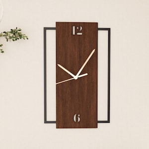 May include: A brown wooden clock with black metal frame and white hands. The clock face has the numbers 12 and 6.