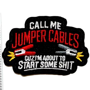 May include: A black embroidered patch featuring the white text CALL ME and CUZ I'M ABOUT TO START SOME SHIT, with red text JUMPER CABLES, a red and a silver jumper cable clamp, and yellow sparks. A ruler shows the patch is 2 inches tall.