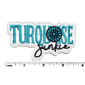 May include: An embroidered patch with white backing featuring the teal text TURQUOISE and the black script text junkie, with a teal flower icon replacing the letter O. A ruler below shows the patch is approximately 4 inches wide.
