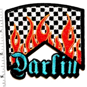 May include: Embroidered patch with a black border, featuring a checkered background, red flames, and the word "Darlin" in turquoise script. The patch measures approximately 3 inches in height and 2.5 inches in width.