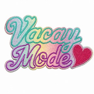 May include: An embroidered patch featuring the text Vacay Mode in a cursive font. The lettering has a gradient of pastel colors including blue, yellow, and pink with a glittery finish. A solid bright pink heart is positioned to the right of the text.