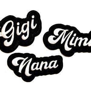 May include: Three embroidered patches with white script lettering on a black background. The patches are in the shape of a cloud. The names "Gigi", "Mimi", and "Nana" are displayed.