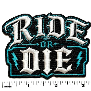 May include: A black embroidered patch featuring the white text RIDE OR DIE with teal accents and two small lightning bolt symbols. The patch is positioned above a white ruler showing a width of approximately 3.5 inches for the design.