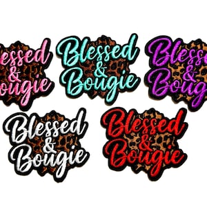 May include: Embroidered patches with the words "Blessed & Bougie" in various colors, including pink, teal, purple, black, and red. Each patch has a leopard print background and a black border.