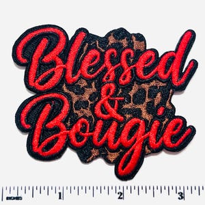 May include: Embroidered patch with the words "Blessed & Bougie" in red script lettering. The text is outlined in black and set against a leopard print background. The patch measures approximately 3 inches wide.