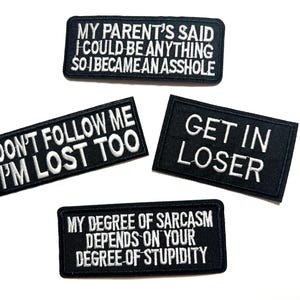 May include: Four black embroidered patches with white text. The patches read: "MY PARENT'S SAID I COULD BE ANYTHING SO I BECAME AN ASSHOLE", "DON'T FOLLOW ME I'M LOST TOO", "GET IN LOSER", and "MY DEGREE OF SARCASM DEPENDS ON YOUR DEGREE OF STUPIDITY".
