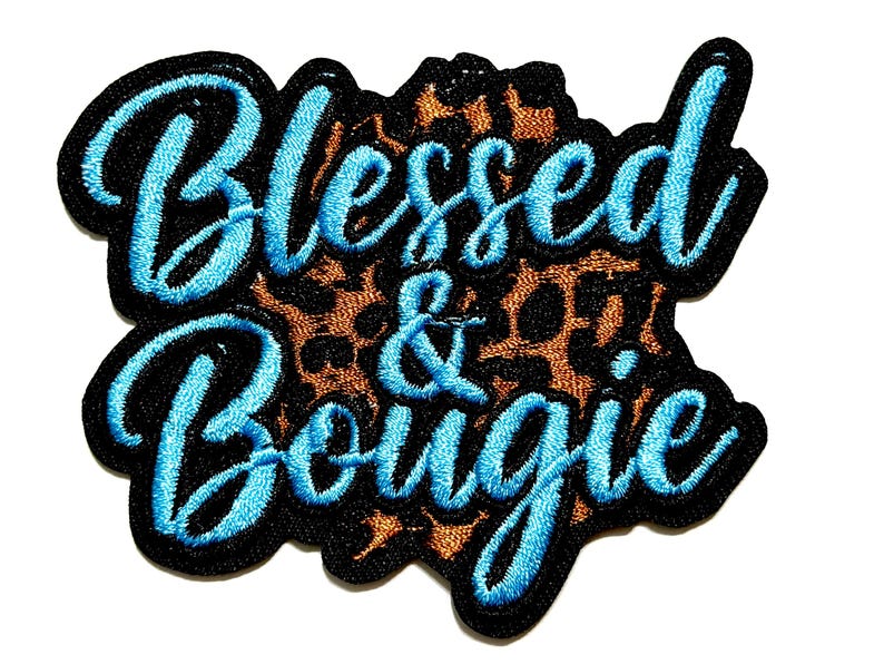 May include: Embroidered patch with the words "Blessed & Bougie" in light blue script. The text is outlined in black and set against a leopard print background. The patch has a black border.