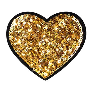 May include: A heart-shaped patch featuring a dense layer of reflective gold sequins covering the surface. The heart has a solid black fabric border that outlines the shape, providing a distinct contrast against the metallic gold sequin embellishments.