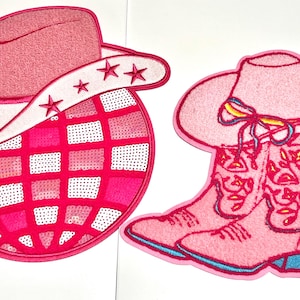 May include: Two pink embroidered patches. One features a cowboy hat with star accents over a disco ball design. The other patch shows a cowboy hat and boots with floral details and a colorful bow.