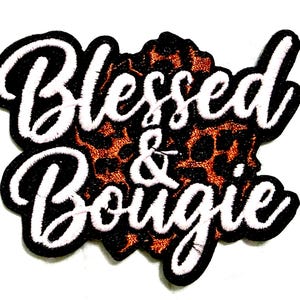 May include: Embroidered patch with the words "Blessed & Bougie" in white script, outlined in black with a white border. The background features a leopard print pattern in shades of brown and black.