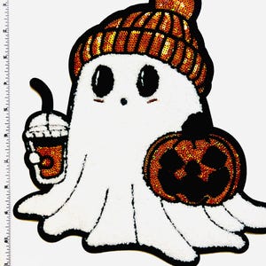 May include: A white ghost-shaped patch with a black outline, wearing a sequined orange beanie. The ghost holds a coffee cup and a jack-o'-lantern. The patch is a Halloween-themed design.