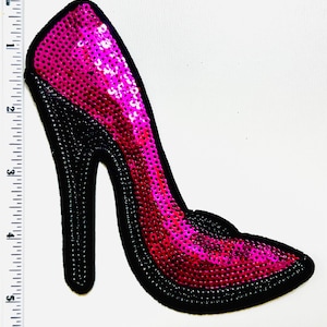 May include: A high-heeled shoe patch with a vibrant pink sequined upper and a black heel and trim. The patch is approximately 5 inches in length, perfect for adding flair to clothing or accessories.