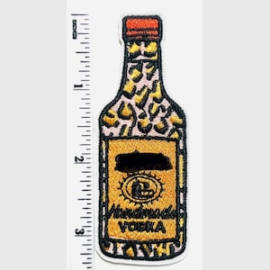 May include: Embroidered patch in the shape of a vodka bottle. The bottle has a leopard print design, a red cap, and a gold label with the words "Handmade Vodka". The patch measures approximately 3 inches in height.