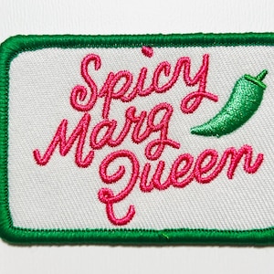 May include: Embroidered patch with the words "Spicy Marg Queen" in pink script, a green chili pepper, and a green border. The patch is rectangular and has a white background.