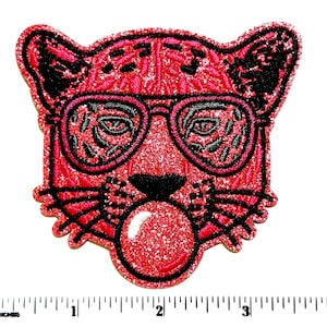 May include: A red glittery patch featuring a stylized leopard head wearing black sunglasses and blowing a bubble. The patch is approximately 3 inches wide and is an iron-on patch.