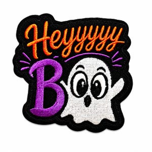 May include: An embroidered patch with a black background featuring the orange text Heyyyyy and the purple text Boo. A white ghost with large black eyes and a surprised expression is positioned next to the letter B, with purple accent lines.