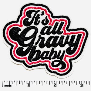 May include: Embroidered patch with the phrase "It's all gravy baby" in black, outlined in red and white. The patch is approximately 3 inches wide.