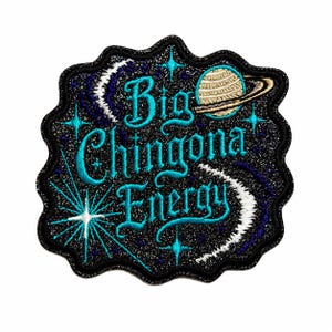 May include: An embroidered patch with a black glittery background featuring the text Big Chingona Energy in bright blue script. The design includes a beige planet with rings, two white crescent moons, and several light blue starburst accents.