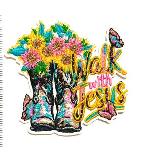 May include: Embroidered patch featuring a pair of cowboy boots filled with sunflowers and other flowers. The boots are turquoise, pink, and brown. The patch includes the text "Walk with Jesus" in a script font, with butterflies.